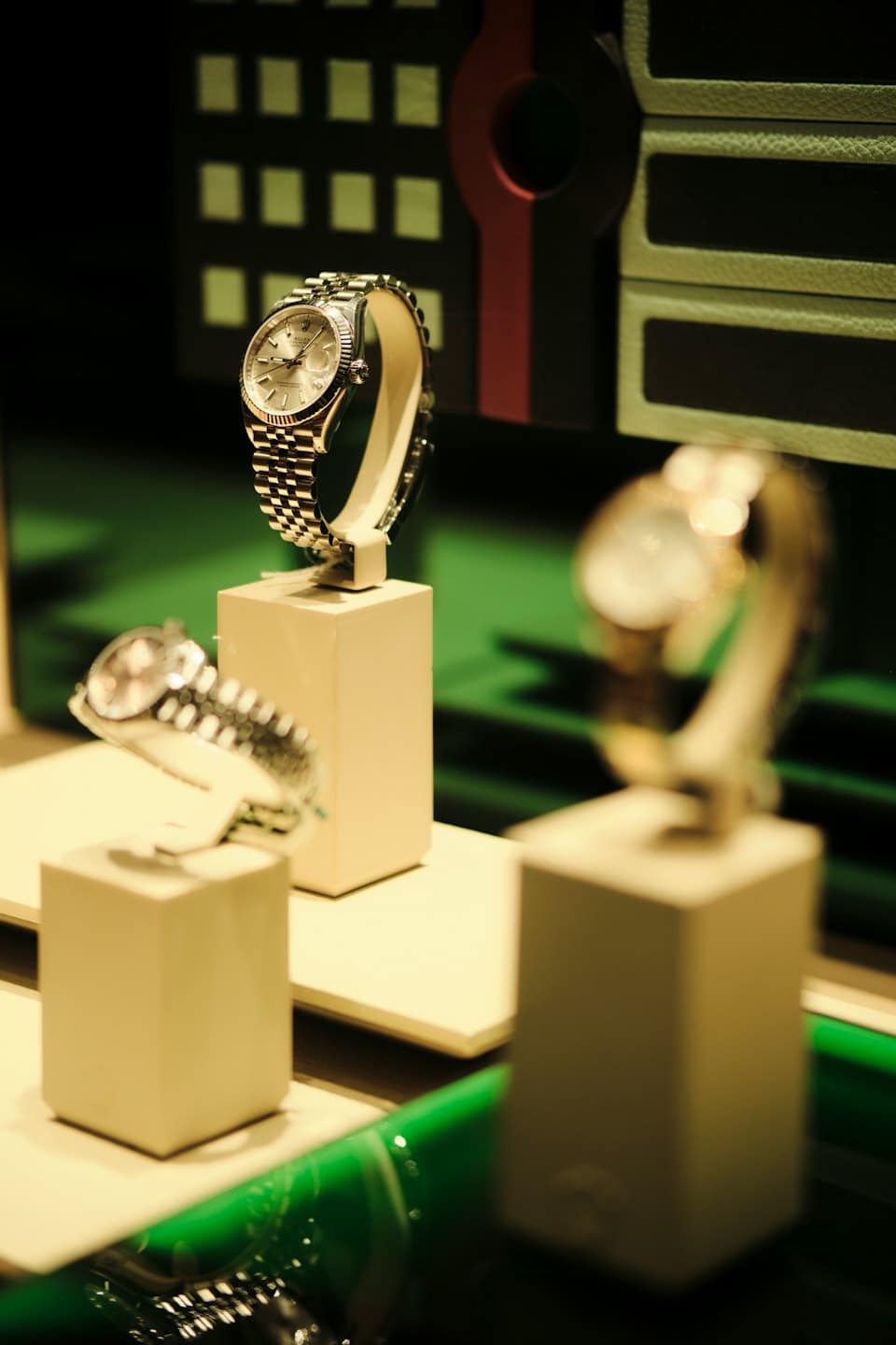 Luxury watches displayed on plinths in a retail shop.