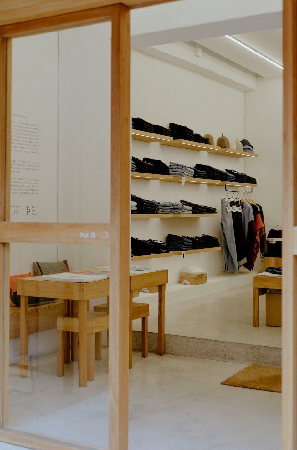 Minimalist clothing boutique featuring neatly folded garments and wooden fixtures.