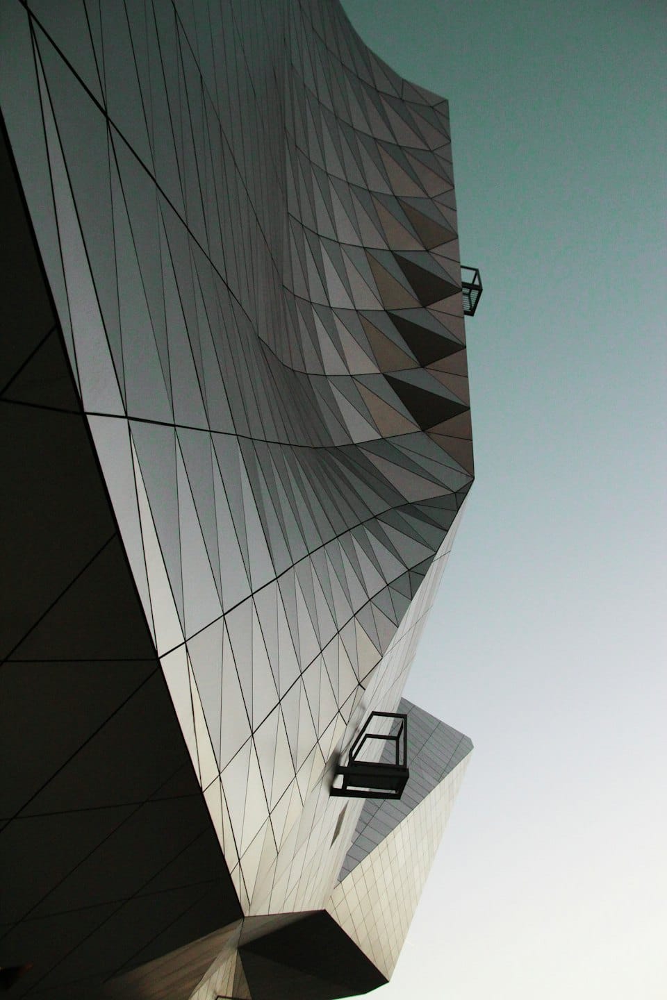 Modern building with a faceted geometric grey facade.