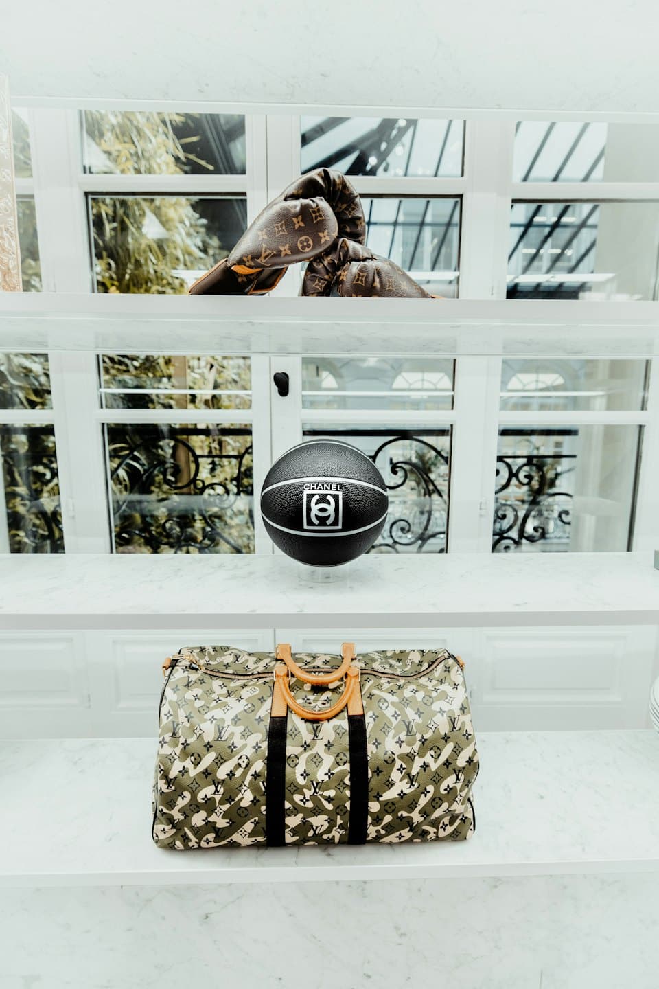Designer sporting goods and bags displayed on marble shelves.